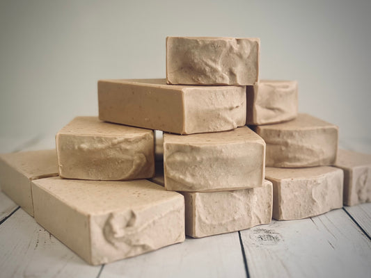 Batch_912 Teakwood and Birch. Stack of brown soap bars on a wooden surface with a neutral background