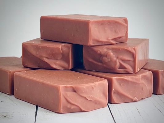Batch_94, Perfect Man, Stack of brown soap bars on a light wooden surface with a neutral background